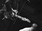 A photo of Elvis Costello and Bruce Thomas of The Attractions taken at Glastonbury 1984.